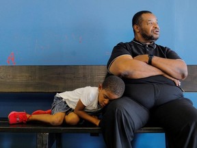 Pastor Clifford Tyson, a former felon working to restore his voting rights, and his napping five year-old grandson Malachi wait for a haircut at Big Boys Barbershop in Tampa, Florida, U.S., September 10, 2019.