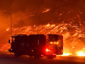 Firefighters battle a wind-driven wildfire in Sylmar, Calif., Oct. 11, 2019.