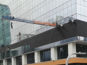A worker is seen dangling from a swing-stage platform in Edmonton.