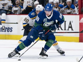 Adam Gaudette of the Vancouver Canucks manoeuvres past Ryan O'Reilly of the St. Louis Blues at Rogers Arena on Nov. 5 in Vancouver.