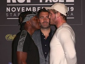 KSI (L) and Logan Paul face off onstage while promoter Eddie Hearn looks on during the KSI VS. Logan Paul 2 - Final Press Conference at TAO Hollywood on November 7, 2019 in Los Angeles, California.