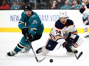 Logan Couture #39 of the San Jose Sharks and Ethan Bear #74 of the Edmonton Oilers go for the puck at SAP Center on November 12, 2019 in San Jose, California.