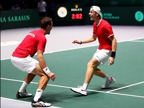 Denis Shapovalov and Vasek Pospisil of Canada celebrate victory in the semi-final doubles match between Russia and Canada at the 2019 Davis Cup at La Caja Magica on Nov. 23, 2019 in Madrid, Spain. (Clive Brunskill/Getty Images)