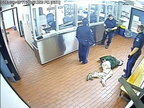 Corey Rogers lies on the floor under police custody at the Halifax police station, wearing a spit hood at about 11 p.m. on June 15, 2016 in this still image taken from surveillance video provided by Nova Scotia Courts.