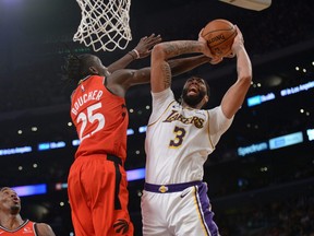 Lakers’ Anthony Davis (right) moves to the basket against Raptors’ Chris Boucher on Sunday.