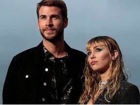 In this file photo taken on June 6, 2019, US singer Miley Cyrus and husband Australian actor Liam Hemsworth arrive for the Saint Laurent Men's Spring-Summer 2020 runway show in Malibu, California.