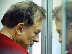Russian professor Oleg Sokolov stands behind glass as he attends a court hearing in Saint Petersburg on November 11, 2019.