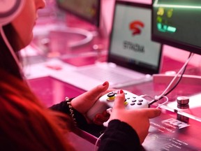 In this file photo taken on August 21, 2019 a visitor plays a cloud-game at the stand of Google Stadia during the Video games trade fair Gamescom in Cologne, western Germany.