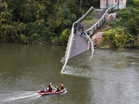 Rescuers sail near a suspension bridge which collapsed on November 18, 2019, in Mirepoix-sur-Tarn, near Toulouse, southwest France.