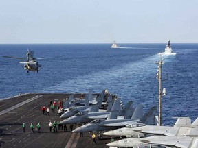 The aircraft carrier USS Abraham Lincoln transits the Strait of Hormuz as an MH-60S Sea Hawk helicopter lifts off from the flight deck on November 19, 2019.