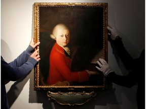 Workers install a portrait due to be sold at auction by Christie's on November 27 which depicts composer Wolfgang Amadeus Mozart as a teenager, painted in January 1770, and attributed to Veronese master Gaimbettino Cignaroli, in Paris, November 12, 2019.