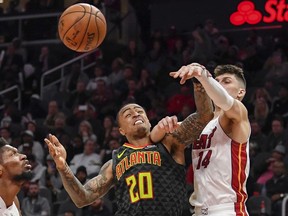 Atlanta Hawks forward John Collins  and Miami Heat guard Tyler Herro battle for the ball during the second half  at State Farm Arena.