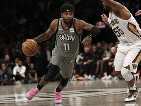 Brooklyn Nets guard Kyrie Irving moves the ball against New Orleans Pelicans guard E'Twaun Moore in the fourth quarter at Barclays Center.