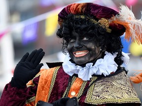 An assistant of Saint Nicholas called "Zwarte Piet" (Black Pete) arrives by boat at the harbour of Scheveningen, Netherlands, November 16, 2019. (REUTERS/Piroschka van de Wouw)