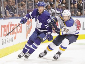 Toronto Maple Leafs' Rasmus Sandin and St. Louis Blues' Ivan Barbashev battle for the puck during a game in October.