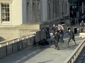 Police officers aim at a man who had stabbed a number of people, on London Bridge, in London, Britain, November 29, 2019 in this still image obtained from a social media video.