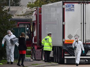 In this file photo taken on Oct. 23, 2019, British Police forensics officers work on lorry, found to be containing 39 dead bodies, at Waterglade Industrial Park in Grays, east of London.