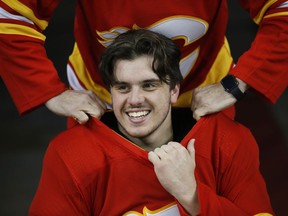 Former Humbolt hockey player Ryan Straschnitzki, who was injured in a team bus crash, gets help putting on his jersey with PX3 AMP hockey team in Calgary, Wednesday, Oct. 30, 2019.