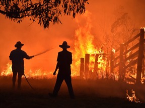 Residents defend a property from a bushfire at Hillsville near Taree, 350 km north of Sydney on Nov. 12, 2019.
