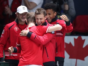 Denis Shapovalov of Canada is congratulated by teammate Vasek Pospisil following his win against Taylor Fritz of The United States during the Davis Cup at La Caja Magica on November 19, 2019 in Madrid. (Alex Pantling/Getty Images)