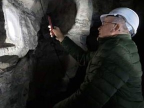 Duncan Carey examines his fathers signature in Maison Blanche, a cavern his father stayed in while fighting in the First World War.