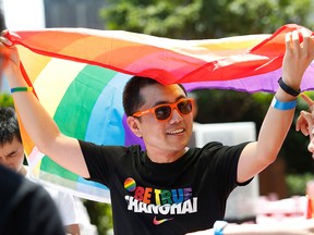 This file picture taken on June 17, 2017 shows a man holding a rainbow flag after taking part in the Pride Run in Shanghai.  (STR/AFP/Getty Images)