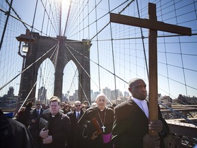 Worshippers lead by Rev. Richard Veras (left), Rev. Nicholas DiMarzio (middle), and Frank Simmonds march over the Brooklyn Bridge in the 17th Way Of The Cross procession on April 06, 2012 in New York. (Michael Nagle/Getty Images)