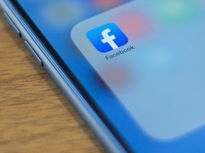 The Facebook logo is seen on a phone in this photo illustration in Washington, D.C., on July 10, 2019.