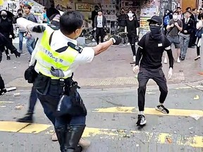 A still image from a social media video shows a police officer aiming his gun at a protester in Sai Wan Ho, Hong Kong, China November 11, 2019. (CUPID PRODUCER via REUTERS)