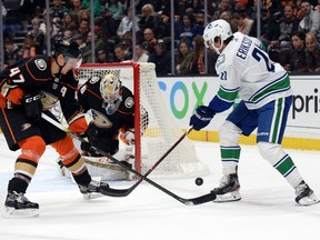 Anaheim Ducks goaltender John Gibson defends the goal as defenceman Hampus Lindholm plays for the puck against Vancouver Canucks left wing Loui Eriksson.