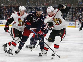 Senators defenceman Nikita Zaitsev takes the puck away from Blue Jackets winger Nick Foligno during the second period of Monday night's game.