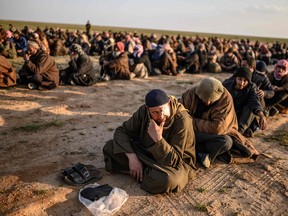 Men suspected of being Islamic State (IS) fighters wait to be searched by members of the Kurdish-led Syrian Democratic Forces after leaving the IS group's last holdout of Baghouz, in Syria's northern Deir Ezzor province on Feb. 22, 2019. (BULENT KILIC/AFP via Getty Images)