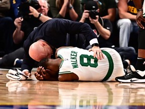 Celtics guard Kemba Walker (8) lies on the court following an injury in the second quarter against the Nuggets at the Pepsi Center in Denver on Friday, Nov. 22, 2019.