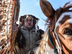 A Lakota man rides a horse with a sacred staff during a ride to meet Brad Upton, descendant of the commander of the Wounded Knee massacre on the Cheyenne River reservation in Eagle Butte, South Dakota, November 7, 2019. (2019 REUTERS/Stephanie Keith)