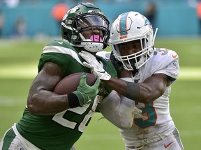 Le'Veon Bell of the New York Jets is tackled by Jomal Wiltz of the Miami Dolphins at Hard Rock Stadium on November 3, 2019 in Miami. (Eric Espada/Getty Images)