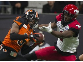 The B.C. Lions' T.J. Lee intercepts a pass intended for Calgary Stampeders receiver Hergy Mayala in a regular season CFL football game on Saturday night at BC Place in Vancouver.