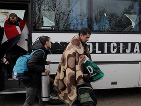 Migrants leave a police bus as they arrive at Vucjak camp near Bihac, Bosnia and Herzegovina, November 15, 2019. (REUTERS/Marko Djurica)