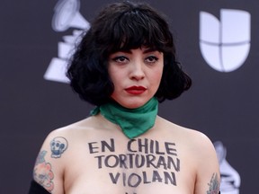 Chilean singer Mon Laferte, exposes her chest with writings reading "In Chile they torture, rape and kill," as she arrives at the 20th Annual Latin Grammy Awards in Las Vegas, Nevada, on Nov. 14, 2019. (BRIDGET BENNETT/AFP via Getty Images)