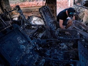 A member of the LeBaron family looks at the burned car where part of the nine murdered members of the family were killed and burned during an ambush in Bavispe, Sonora mountains, Mexico, on Nov.  5, 2019.