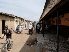 People pass by the site of Mallam Nigas's Islamic school and rehabilitation centre, which was raided by police last week, in Katsina, Nigeria October 18, 2019. Picture taken October 18, 2019.