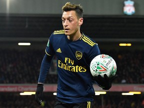 Arsenal's Mesut Ozil retrieves the ball during the English League Cup match against Liverpool at Anfield in Liverpool, October 30, 2019. (PAUL ELLIS/AFP via Getty Images)