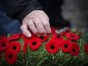 Poppies are placed on a wreath at a cenotaph during a Remembrance Day service in Winnipeg, Saturday, Nov. 11, 2017.