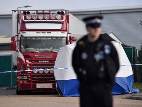 In this file photo taken on October 23, 2019, a police officer secures the cordon at the scene where a lorry, found to be containing 39 dead bodies, was discovered at Waterglade Industrial Park in Grays, east of London. (BEN STANSALL/AFP via Getty Images)