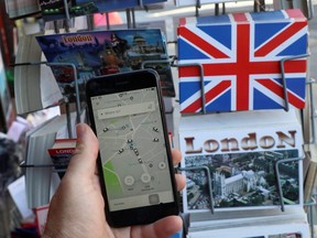A photo illustration shows the Uber app and London themed postcards in London, England, on June 26, 2018.