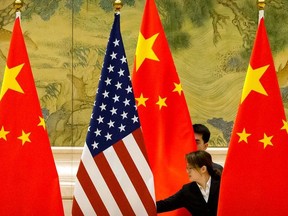 Chinese staff members adjust U.S. and Chinese flags before the opening session of trade negotiations between U.S. and Chinese trade representatives at the Diaoyutai State Guesthouse in Beijing, China February 14, 2019.