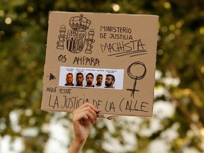 A protester holds a sign during a demonstration against the release on bail of five men known as the "Wolf Pack in Seville, Spain, June 22, 2018. (REUTERS/Marcelo del Pozo/File Photo)