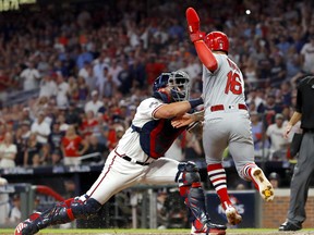 Kolten Wong of the St. Louis Cardinals is tagged out at home plate by Francisco Cervelli of the Atlanta Braves in an attempt to score from first base on a hit by teammate Matt Carpenter (not pictured) during the eighth inning in game one of the National League Division Series at SunTrust Park on October 03, 2019 in Atlanta, Georgia.