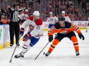 Connor McDavid of the Edmonton Oilers battles against Canadiens' Nick Cousins at Rogers Place on Saturday, Dec. 21, 2019, in Edmonton.