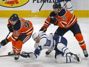 Toronto Maple Leafs Zach Hyman (middle) is checked by Edmonton Oilers Ryan Nugent-Hopkins (left) and James Neal (right) during first period NHL hockey game action in Edmonton on Saturday December 14, 2019.