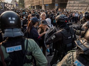 Riot police block a section of Salisbury Road as people take part in a march from the Tsim Sha Tsui district to Hung Hom in Hong Kong on December 1, 2019.